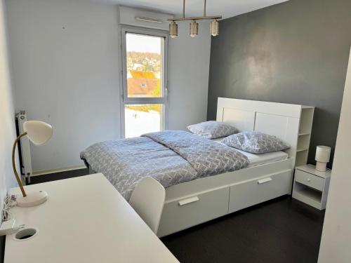une chambre blanche avec un lit et une fenêtre dans l'établissement Appartement entièrement meublé de 57m Chanteloup les vignes Centre ville, à Chanteloup-les-Vignes