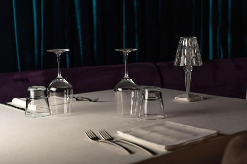 a table with wine glasses and napkins on it at Emotional Grand Motel in Fontaneto dʼAgogna