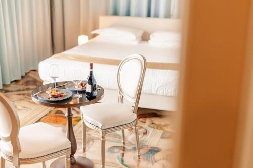 a room with a table and two chairs and a bed at Emotional Grand Motel in Fontaneto dʼAgogna