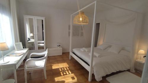 a white bedroom with a bed and a desk and a desk at Big House on Barcelona s Border in Hospitalet de Llobregat