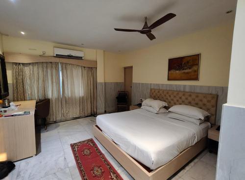 a bedroom with a bed and a ceiling fan at Sher-E-Punjab in Kolkata