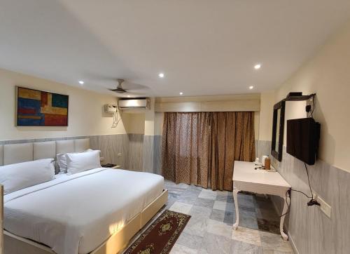 a hotel room with a bed and a television at Sher-E-Punjab in Kolkata