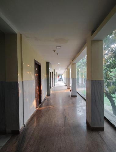 an empty hallway of a building with wood floors and windows at Sher-E-Punjab in Kolkata
