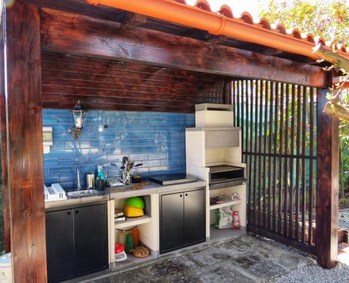 an outdoor kitchen with a sink and a refrigerator at Quinta do Sol in Alijó