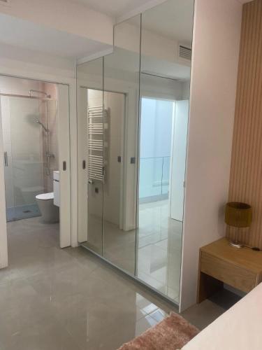 a glass shower in a bathroom with a toilet at Cantinho do Silvano in Gimonde