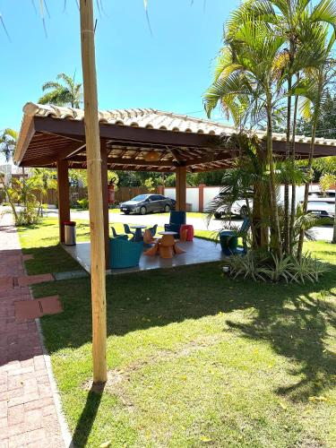 a pavilion with a table and chairs in a park at Itacimirim Bioflora in Itacimirim