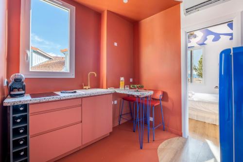 une cuisine orange avec un évier et une fenêtre dans l'établissement 