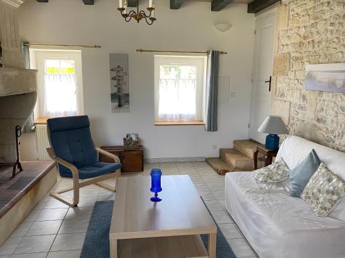un salon avec un canapé et une table dans l'établissement Les gîtes des Lauriers roses Chambre privée Île d Oléron, à Geay