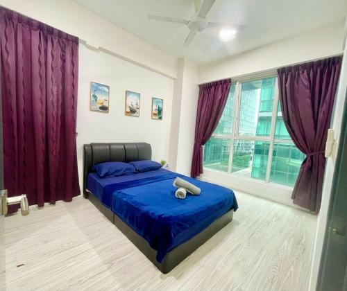 a bedroom with a bed with blue sheets and purple curtains at Ea gathering homestay in Kota Kinabalu