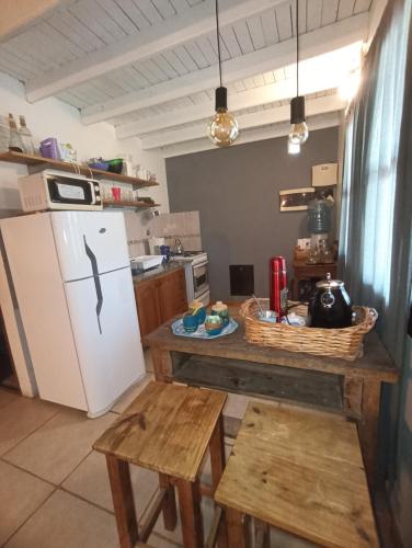 a kitchen with a refrigerator and a table with benches at Quinta Los Sauces Suipacha in Suipacha