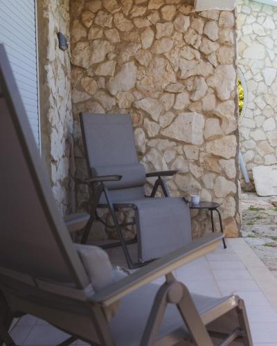 a chair sitting on a table next to a stone wall at Casa das Milheirices in São Mamede