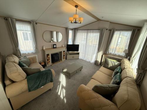 a living room with two couches and a fireplace at Cuckoo Lodge with Hot Tub at Brickyard Lakes in Amotherby