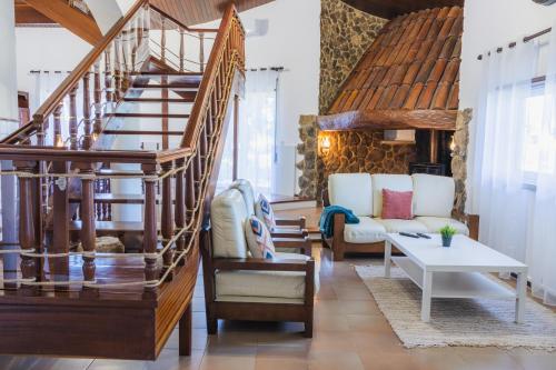 a living room with a staircase and a couch at Casa das Milheirices in São Mamede