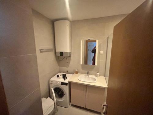 a bathroom with a sink and a washing machine at Apartments Krug in Budva