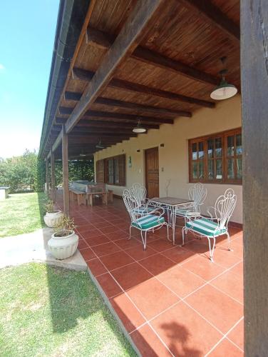 a patio with chairs and a table on a patio at Quinta Los Sauces Suipacha in Suipacha