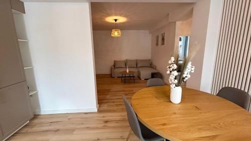 a dining room table with a vase of flowers on it at Bucovina Home Apartament in Gura Humorului