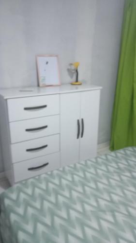 a bedroom with a white dresser and a bed at La Casa del Monica in Itacaré