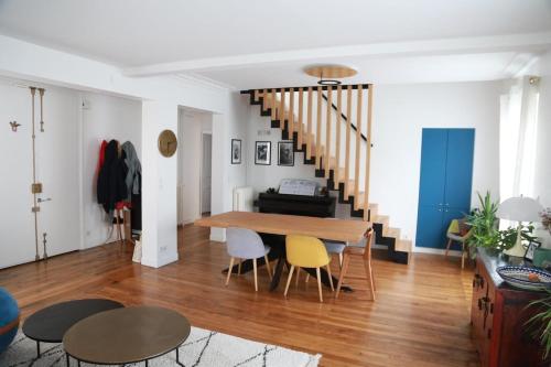 un salon avec une table et des chaises et un escalier dans l'établissement Beautiful Duplex, à Issy-les-Moulineaux
