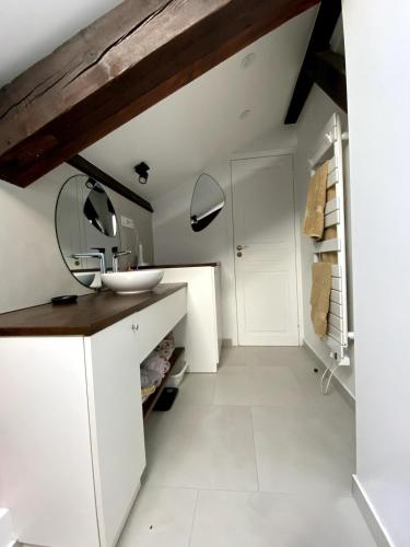 La salle de bains est pourvue de placards blancs et d'un lavabo. dans l'établissement Beautiful Duplex, à Issy-les-Moulineaux
