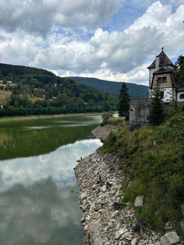 a building on the side of a river next to a building at ALPINA Mountain View Apartment in Špindlerův Mlýn