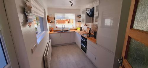 a small kitchen with white cabinets and a sink at Home away from home in Belfast