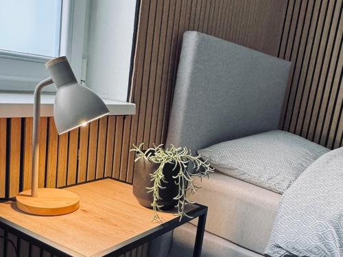 a lamp sitting on a table next to a bed at Ferienwohnung am Hoeschplatz in Düren - Eifel