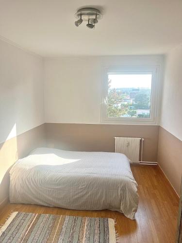 une chambre avec un lit blanc et une fenêtre dans l'établissement Ma parenthèse, à Dieppe