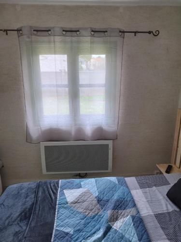 a bedroom with a window with a bed and a radiator at Espace Fakayo in LʼIsle-dʼEspagnac