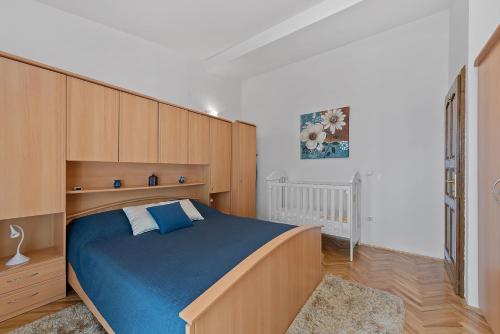 a bedroom with a large bed with blue sheets at Villa Almas with swimming pool, tennis court, sauna, gym, grill house in Neorić
