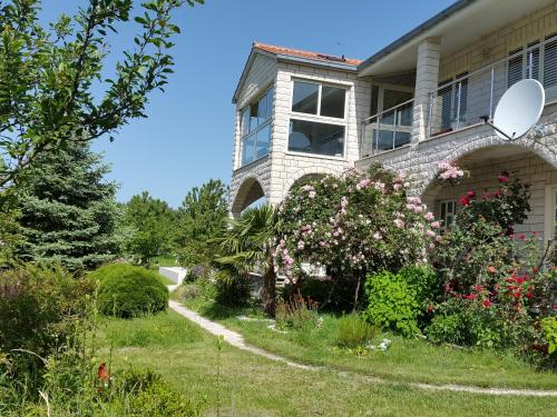 a house with a garden in front of it at Villa Almas with swimming pool, tennis court, sauna, gym, grill house in Neorić