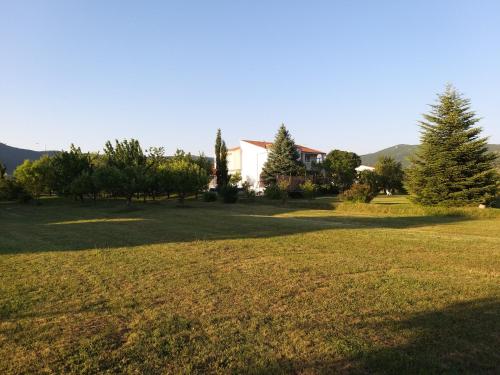 a large yard with trees and a house at Villa Almas with swimming pool, tennis court, sauna, gym, grill house in Neorić