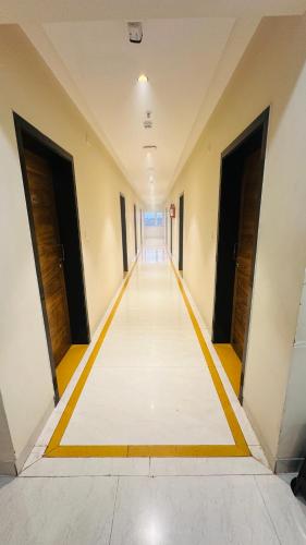 an empty corridor in a building with doors open at Hotel Gokulam Grand in Pithāpuram