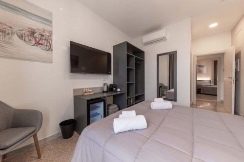 a bedroom with a large white bed and a chair at auntieshouseroma in Rome
