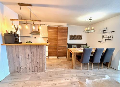 a kitchen and dining room with a wooden table and chairs at BELLE KITZ PURE im Zentrum by Belle Stay in Kitzbühel