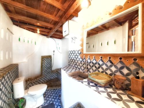 a bathroom with a white toilet in a room at Villa Maayun, a nest in paradise in Letman