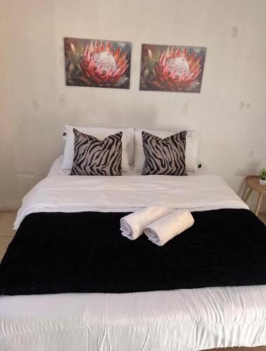 a white bed with two towels on top of it at BEGIN GUESTHOUSe in Ermelo