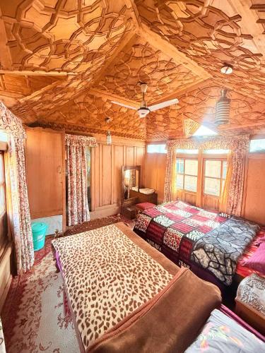 シュリーナガルにあるHeritage Shreen Houseboatのベッドが2つあり、天井が木製の寝室