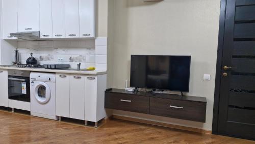 a kitchen with a washing machine and a tv at AIRPORT&APARTMENT&parking in Chişinău