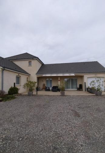 a house with a gravel driveway in front of it at La Maison au bord de Saône in Pagny-la-Ville