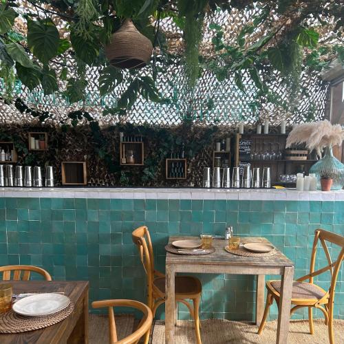 une table et des chaises dans un restaurant avec des carreaux verts dans l'établissement Holiday home for families close to shops and beach, à Capbreton
