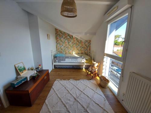 Cet appartement comprend une chambre avec un lit et une fenêtre. dans l'établissement Holiday home for families close to shops and beach, à Capbreton