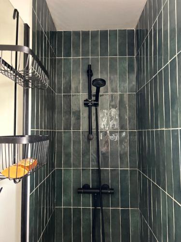 La salle de bains est pourvue d'une douche avec du carrelage vert. dans l'établissement Holiday home for families close to shops and beach, à Capbreton