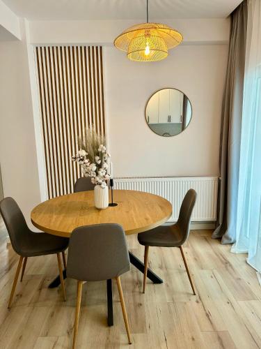 a dining room table with chairs and a mirror at Bucovina Home Apartament in Gura Humorului