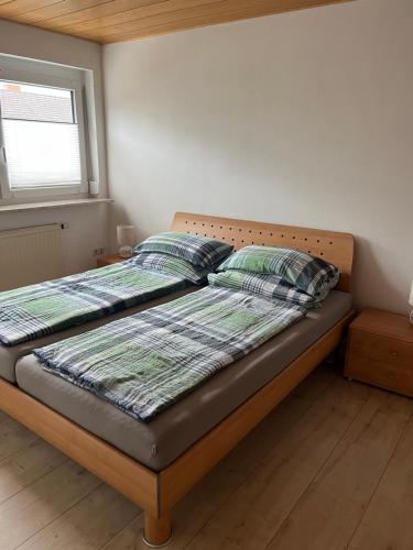 a bed with a wooden headboard in a bedroom at Ferienwohnung nahe Ulm/Laupheim in Laupheim