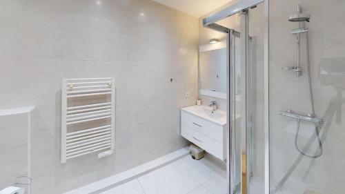 a white bathroom with a shower and a sink at Superbe T2 refait à neuf avec balcon vue montagne à un arrêt de Monaco in Roquebrune-Cap-Martin