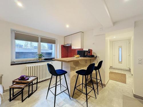 une cuisine avec deux tabourets de bar et un comptoir dans l'établissement Le Studio de Lisa, à Strasbourg