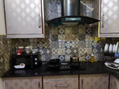 a kitchen with a stove and a microwave at Furnished Private 1 BR Ground Floor in DHA in Lahore