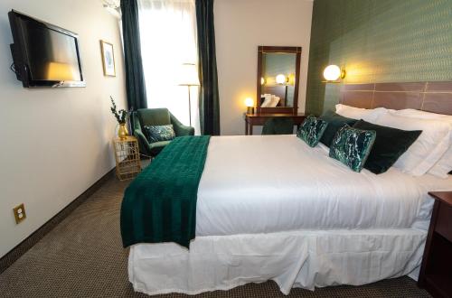 a hotel room with a large bed and a television at Hotel Dorion in Montréal