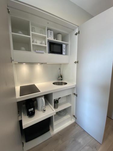 a kitchen with a sink and a microwave at NOX Kensington in London