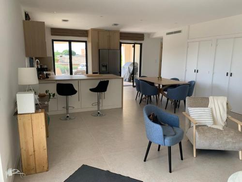 Il comprend une cuisine et un salon avec des chaises et une table. dans l'établissement Superbe appartement 4 Pièces - Accès Piscine, à Cagnes-sur-Mer